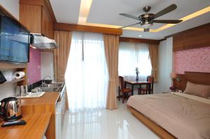 sypialnia z łóżkiem oraz kuchnia ze zlewem w obiekcie Green Harbor Hotel & Service Apartment w Patong Beach
