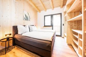 a bedroom with a bed in a room with wooden walls at Casa Goingsport in Going am Wilden Kaiser