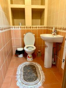 La salle de bains est pourvue de toilettes et d'un lavabo. dans l'établissement 452 Возле Байтерека для компании 1-6 человек с 2 кроватями и диваном, à Astana