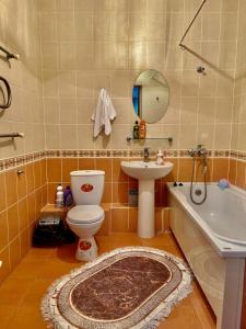 La salle de bains est pourvue de toilettes, d'un lavabo et d'une baignoire. dans l'établissement 452 Возле Байтерека для компании 1-6 человек с 2 кроватями и диваном, à Astana
