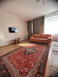 a living room with a couch and a rug at 452 Возле Байтерека для компании 1-6 человек с 2 кроватями и диваном in Astana
