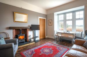 a living room with a fireplace and a table at Argaty Cottage in Doune