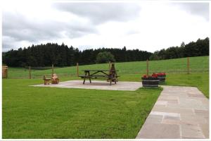 einen Park mit einem Picknicktisch auf einem Feld in der Unterkunft Argaty Cottage in Doune