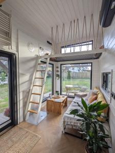a tiny house with a bed and a ladder at Tinyhaus Marie von Tinyhaus Steinhude in Steinhude