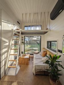 ein Wohnzimmer eines winzigen Hauses mit einem Bett und einer Treppe in der Unterkunft Tinyhaus Marie von Tinyhaus Steinhude in Steinhude