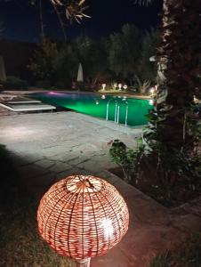 an umbrella in front of a swimming pool at night at Riad Sidi Hicham in Marrakesh