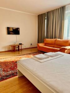 a living room with a bed and a couch at 452 Возле Байтерека для компании 1-6 человек с 2 кроватями и диваном in Astana