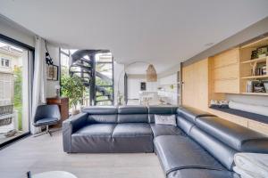 uma sala de estar com um grande sofá de couro em Spacious Bordeaux family home with swimming pool em Bordéus