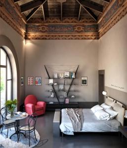 een slaapkamer met een bed en een rode stoel bij Interno Marche Design Experience Hotel in Tolentino