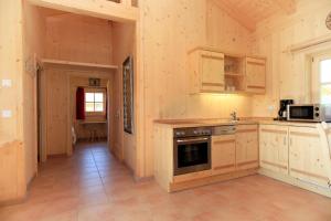 a kitchen with wooden cabinets and a stove at Alpenchalets Hotel Lambach in Seebruck