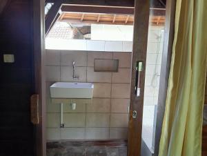 a bathroom with a sink and a mirror at Villa Lumbung Petanahan in Jembrana