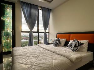 a bedroom with a bed and a large window at Okide F0525 in Phnom Penh