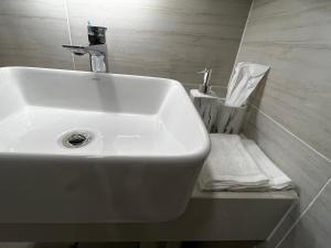 a white sink in a bathroom with a towel at Okide F0525 in Phnom Penh