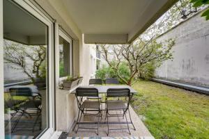 einen Tisch und Stühle auf einer Terrasse mit Garten in der Unterkunft Pleasant flat in Bordeaux with terrace and parking in Bordeaux