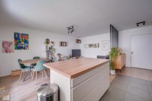 a kitchen with a counter and a table with chairs at Pleasant flat in Bordeaux with terrace and parking in Bordeaux
