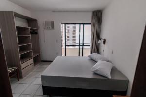 1 dormitorio con 1 cama grande y balcón en Residencial Chanel, en Balneário Camboriú