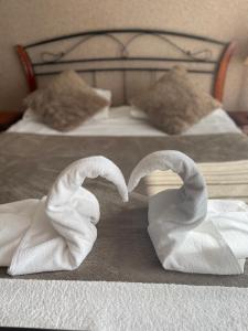 dwa łabędzie zrobione z ręczników na łóżku w obiekcie Zajazd nad Zalewem Dzibice -Pensjonat, Agroturystyka w mieście Dzibice