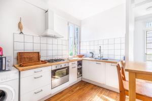 Il comprend une cuisine avec des appareils électroménagers blancs et du parquet. dans l'établissement Beautiful apartment in Bordeaux with garden, à Bordeaux