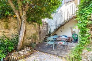 ボルドーにあるBeautiful apartment in Bordeaux with gardenの階段の横にテーブルと椅子付きのパティオ