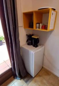 a small refrigerator with a coffee maker on top of it at Chez Anne - Aux Délices de Maurice in Saint Martin