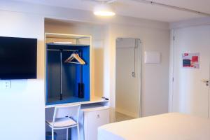 a room with a table and a chair and a lamp at Liiv Hub - Natal PontaNegra in Natal
