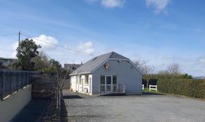 a small blue house with a fence around it at Quiet 2-Bedroom Buncrana Home in Buncrana