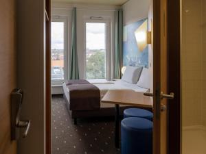 um quarto de hotel com uma cama e uma janela em B&B Hotel Fulda-City em Fulda