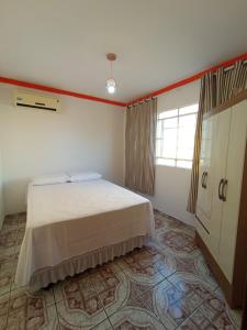 a bedroom with a white bed and a window at Casa Bela vista São José in Piranhas
