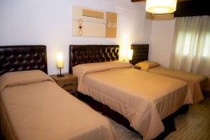 2 camas en una habitación de hotel con 2 lámparas en Hotel Internacional, en Chuy