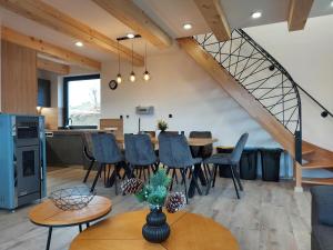 a dining room and kitchen with a table and chairs at Chata Elegant in Bešeňová