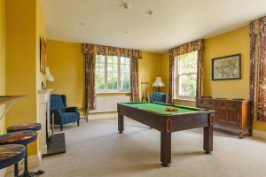 una mesa de billar en una habitación con paredes amarillas en Saham Grove Hall by Group Retreats en West Bradenham