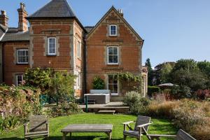 una casa con mesa y sillas en el patio en Saham Grove Hall by Group Retreats en West Bradenham