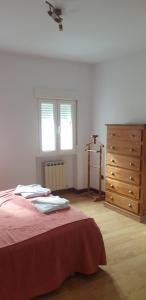 um quarto com uma cama, uma cómoda e 2 janelas em Casa Telares Ávila em Ávila