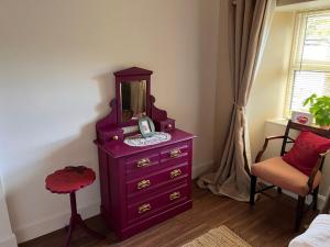 a purple dresser with a mirror on top of it at Berry View - Idyllic cosy cottage on berry farm in Blairgowrie