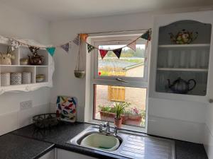 uma cozinha com um lavatório e uma janela em Berry View - Idyllic cosy cottage on berry farm em Blairgowrie