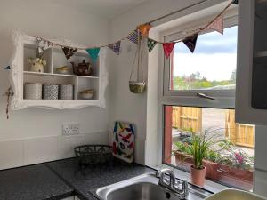 a kitchen with a sink and a window at Berry View - Idyllic cosy cottage on berry farm in Blairgowrie