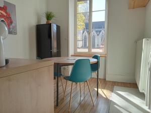 La cuisine est équipée d'une table, de chaises et d'un réfrigérateur. dans l'établissement Nancy Gare Centre Parking, à Nancy