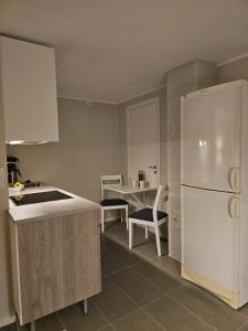 Il comprend une cuisine équipée d'un réfrigérateur blanc et d'une table. dans l'établissement Leilighet, à Porsgrunn