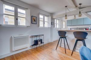 kuchnia z 2 stołkami barowymi i telewizorem w obiekcie Bel appartement Bordeaux centre Pey Berland w mieście Bordeaux