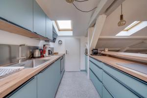 kuchnia z niebieskimi szafkami i zlewem w obiekcie Bel appartement Bordeaux centre Pey Berland w mieście Bordeaux