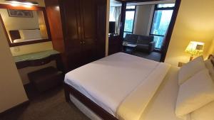 um quarto de hotel com uma cama grande e uma cadeira em Times Square Hotel Service Suite KL em Kuala Lumpur