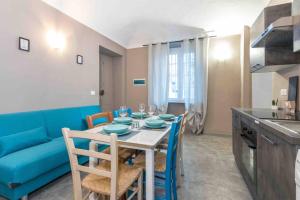 uma sala de jantar com uma mesa e um sofá azul em [Suite della Mole] Torino-Downtown em Turim