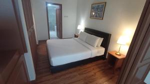 um quarto com uma cama branca e 2 candeeiros em Times Square Hotel Service Suite KL em Kuala Lumpur