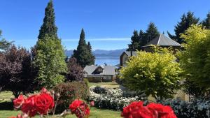 a view of a house and a garden with red flowers at Huinid Bustillo Cabañas in San Carlos de Bariloche +13 photos