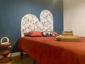 um quarto com uma cama com uma colcha laranja em Jungle Chic em Saint-Avold