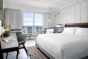a hotel room with a bed and a desk and a bedroom at Cadillac Hotel & Beach Club, Autograph Collection in Miami Beach