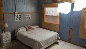 a small bedroom with a bed and a window at Cabaña Rio Sur in Junín de los Andes