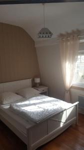 - un lit blanc dans une chambre avec fenêtre dans l'établissement Duplex avec 3 chambres à 30m de la plage, à Merlimont