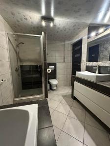 bagno con vasca, lavandino e servizi igienici di Apartament BeskidSki 2 a Szczyrk