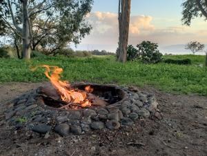 a fire pit in the middle of a field at Bed & Bread in Chorazim